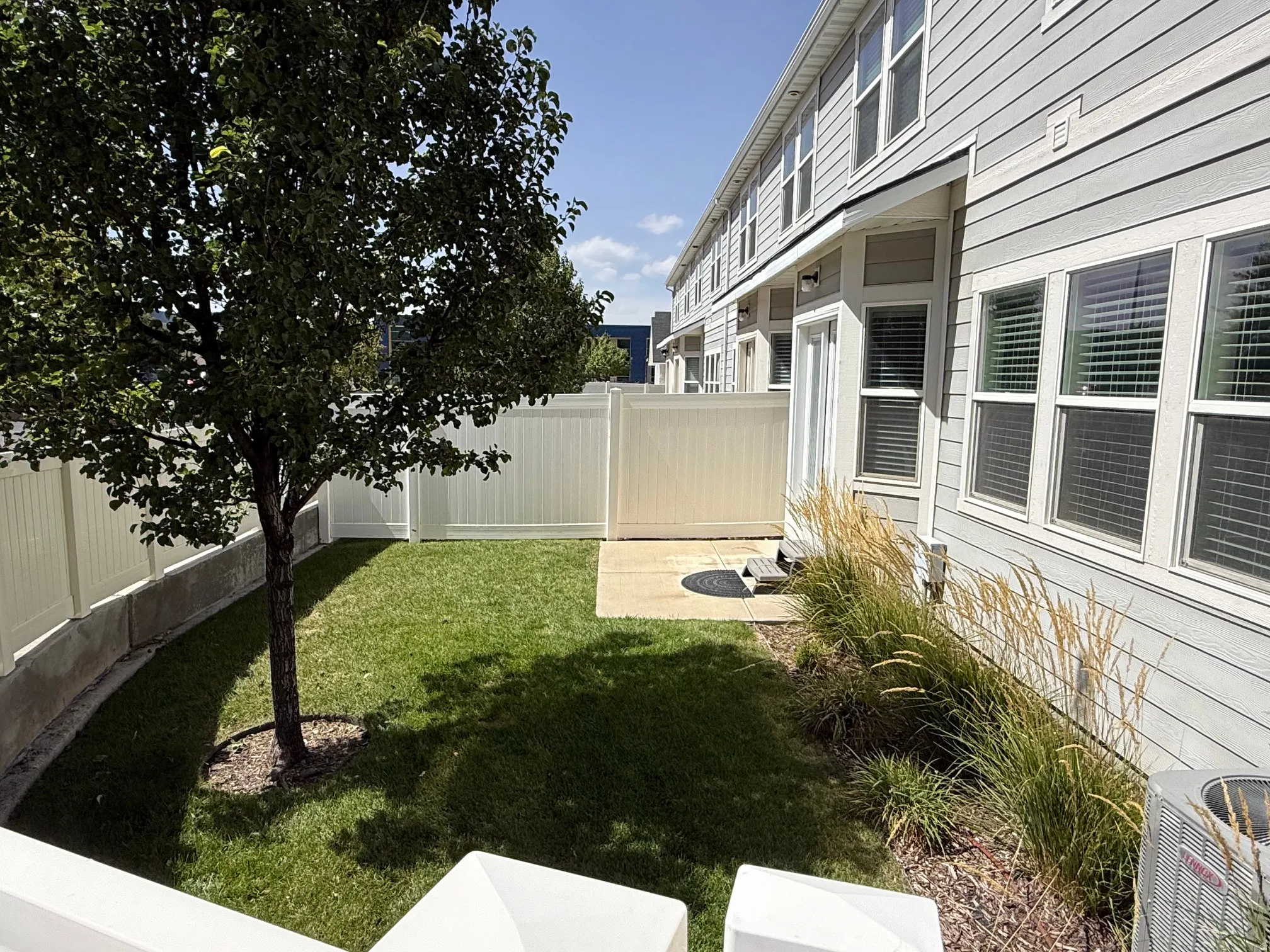Private, fully fenced backyard area featuring a manicured lawn
