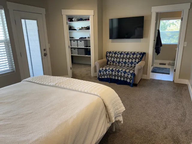 Spacious primary suite with Plush carpeting and neutral-toned walls create a cohesive ambiance