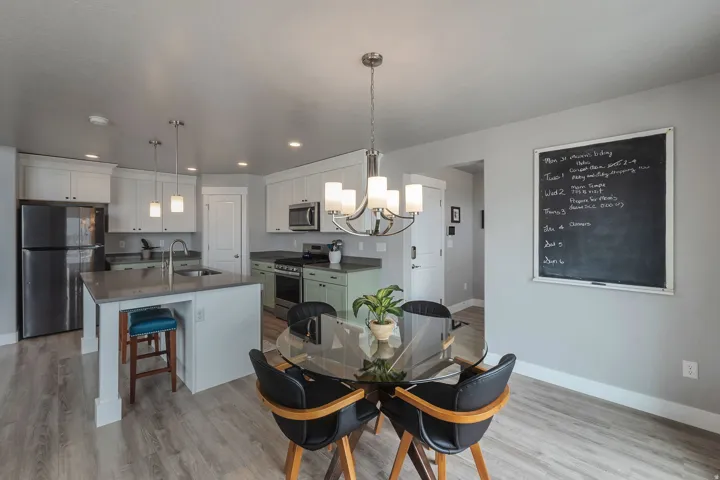 Open-concept kitchen with a central island, stainless steel appliances, and wood-finish flooring