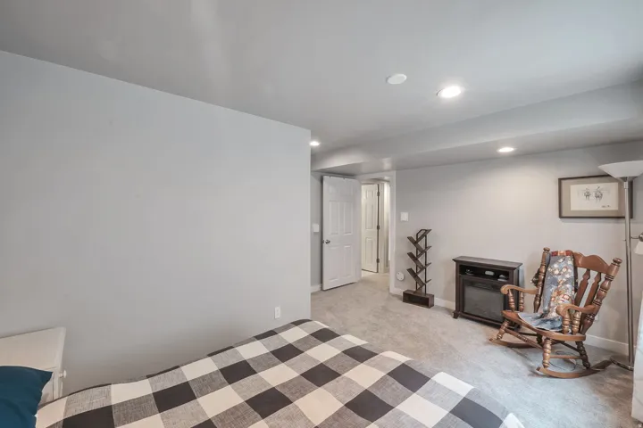 Recessed ceiling lighting, light gray wall finishes, light-colored carpet flooring, white interior doors