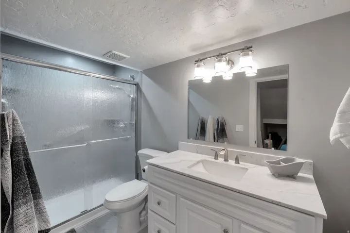 Vanity with white cabinetry, integrated sink, and white countertop