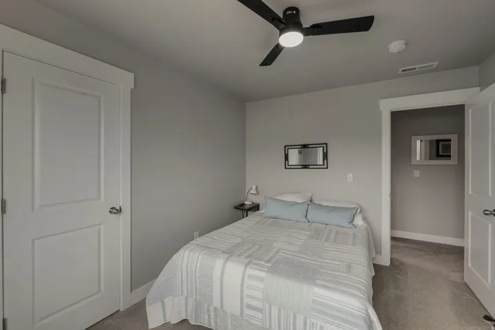 Wall-to-wall carpeting, crisp white trim, and a contemporary ceiling fan with integrated lighting