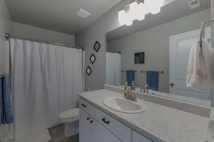 Bathroom with a vanity featuring white cabinetry, a light-colored countertop, and a single basin sink