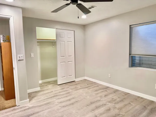 Recessed lighting, ceiling fan with integrated lighting, wood-finish flooring, sliding closet doors, and window with blinds