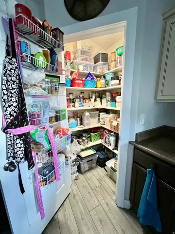 Walk-in pantry with ample shelving and door-mounted storage