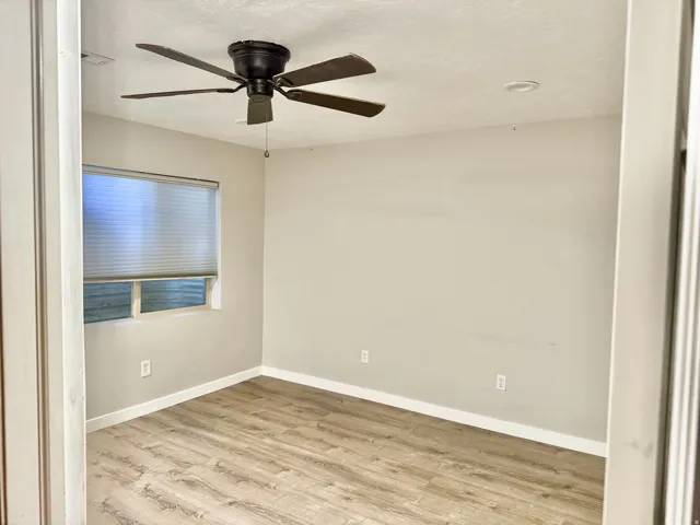 Wood-finish flooring, ceiling fan, recessed lighting, window with blinds