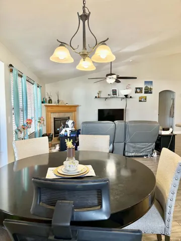 Sloped ceiling with ceiling fan, recessed lighting, and a chandelier