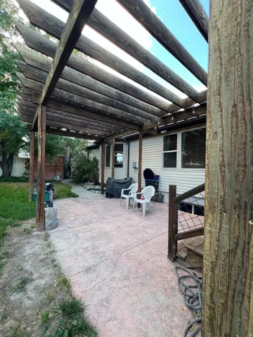 Attached wooden pergola over a textured concrete patio