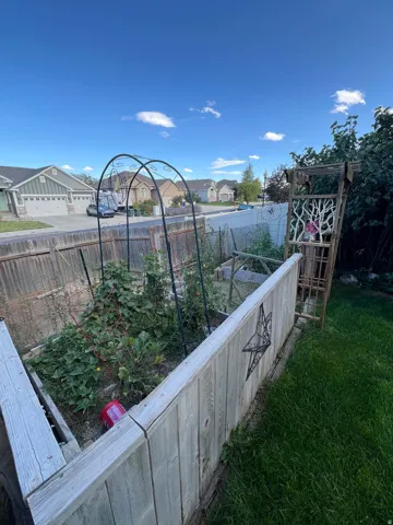 Raised garden beds with integrated trellises and wood fencing