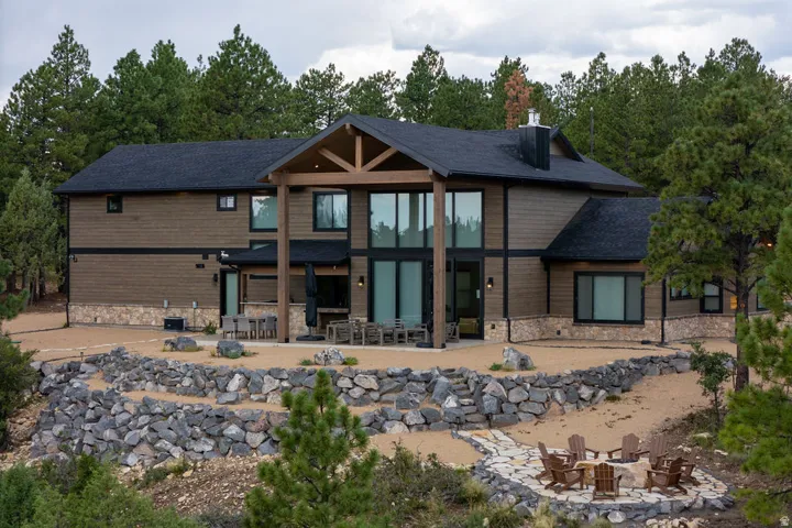 Modern architectural design featuring large format windows and a prominent covered patio