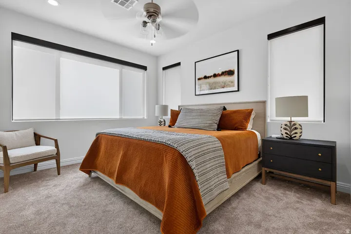 Recessed lighting accents a ceiling fan, complemented by soft carpet flooring