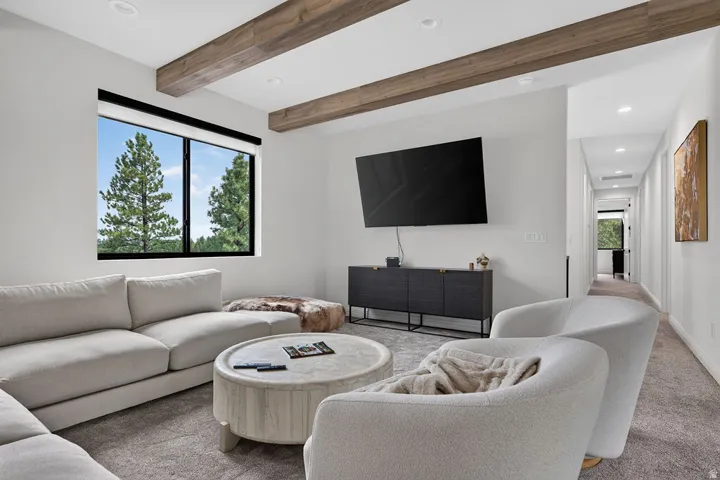 Recessed lighting, wood-finish ceiling beams, and a large window