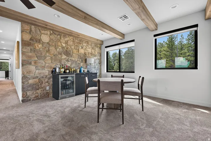 Stone accent wall with built-in bar cabinetry and beverage refrigerator