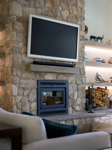 Stone-clad fireplace with a built-in firebox, featuring a substantial mantel shelf