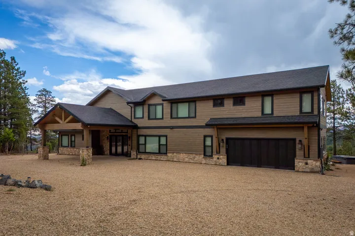 Two-story residence featuring horizontal siding and stone accents