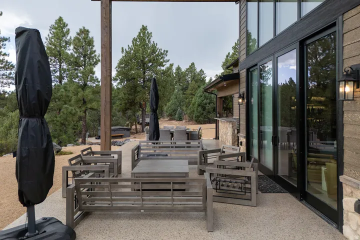 Expansive outdoor patio with a textured concrete surface, framed by a wood-paneled exterior