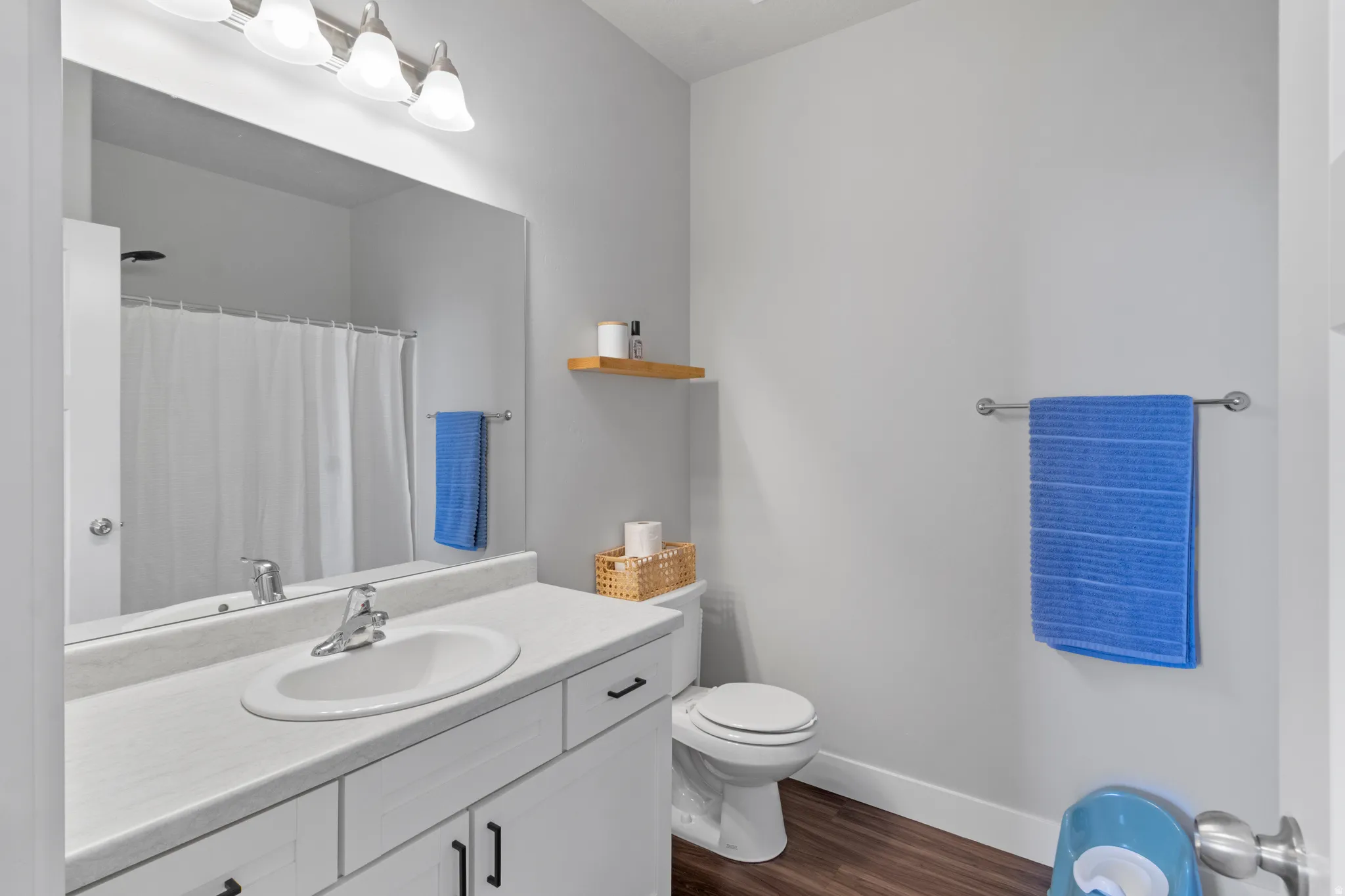 White vanity with matte black hardware, integrated sink, and full-width mirror