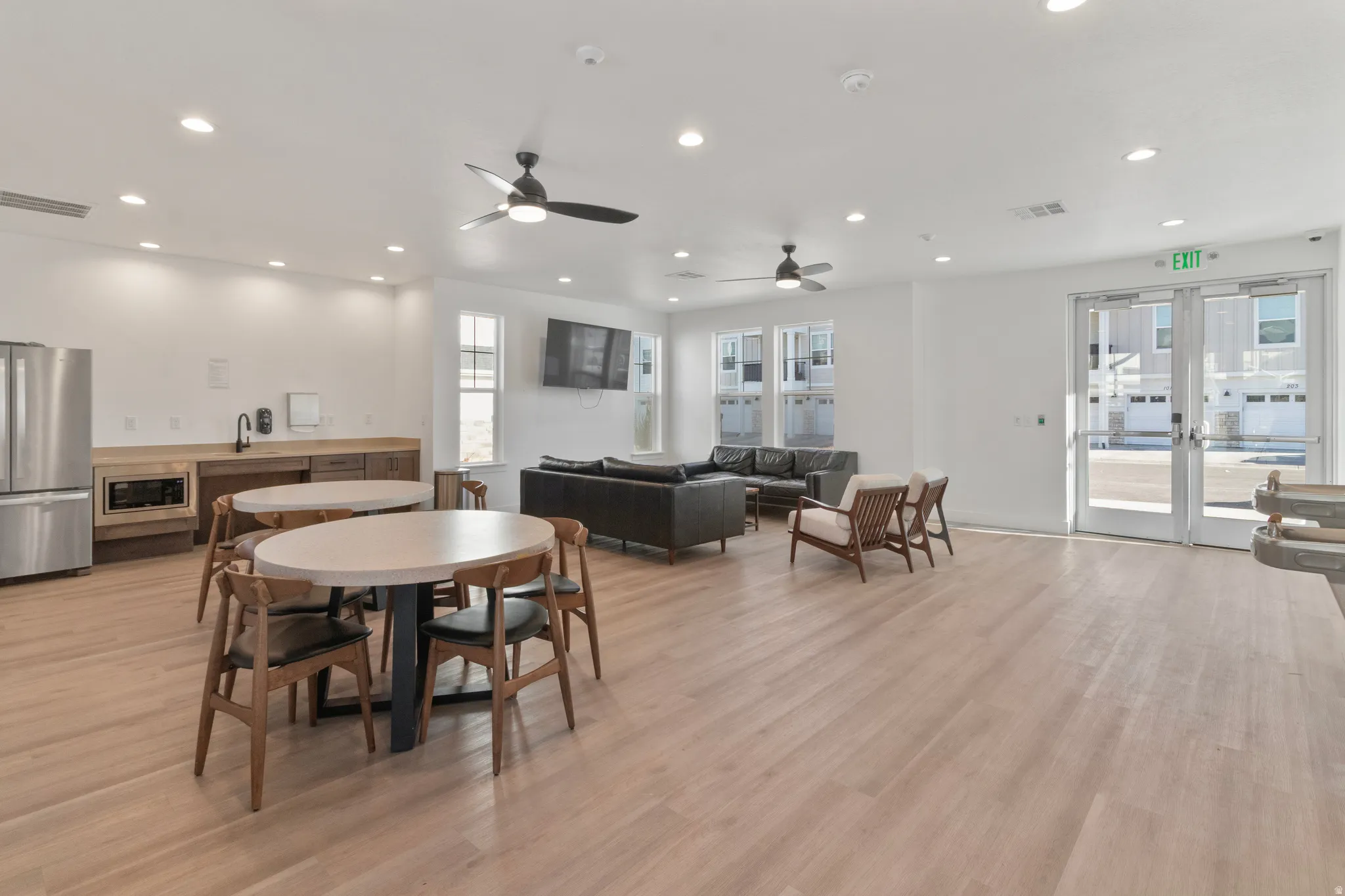 Recessed lighting, wood-finish flooring, built-in cabinetry, stainless steel appliances, and ceiling fans