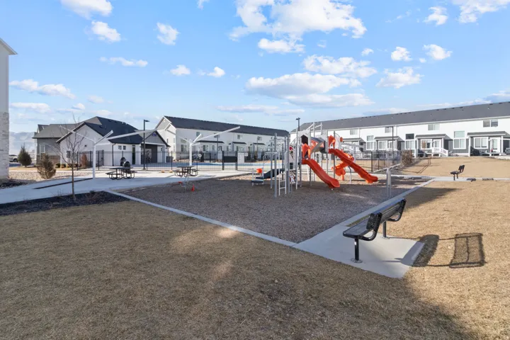Outdoor playground area with multiple slides, a gravel play surface, and dedicated seating