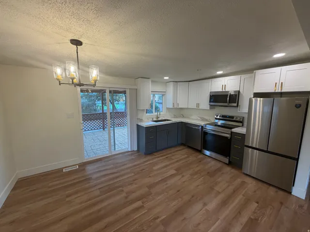 Updated kitchen with two-tone cabinetry, stainless steel appliances, and solid surface countertops