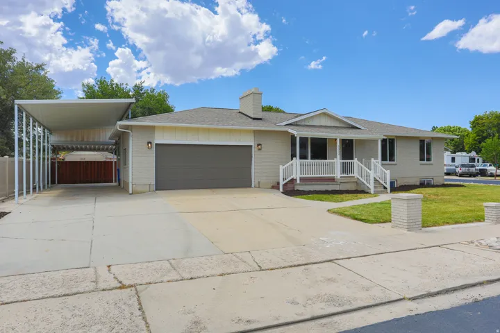Contemporary single-story residence with an attached garage, covered carport, and a welcoming front porch with white railings