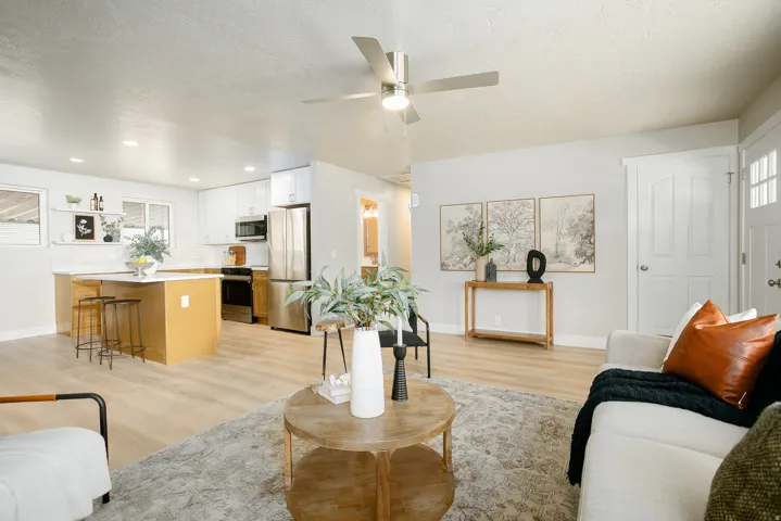 Kitchen featuring white cabinetry, stainless steel appliances, a center island with seating, and wood-finish flooring