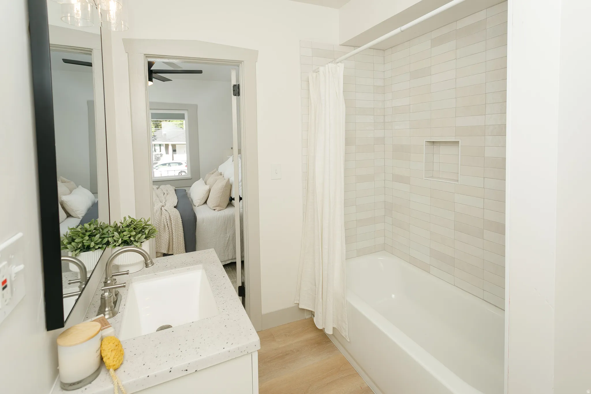Bathroom featuring a white vanity with an integrated sink, brushed nickel faucet, and a large wall-mounted mirror