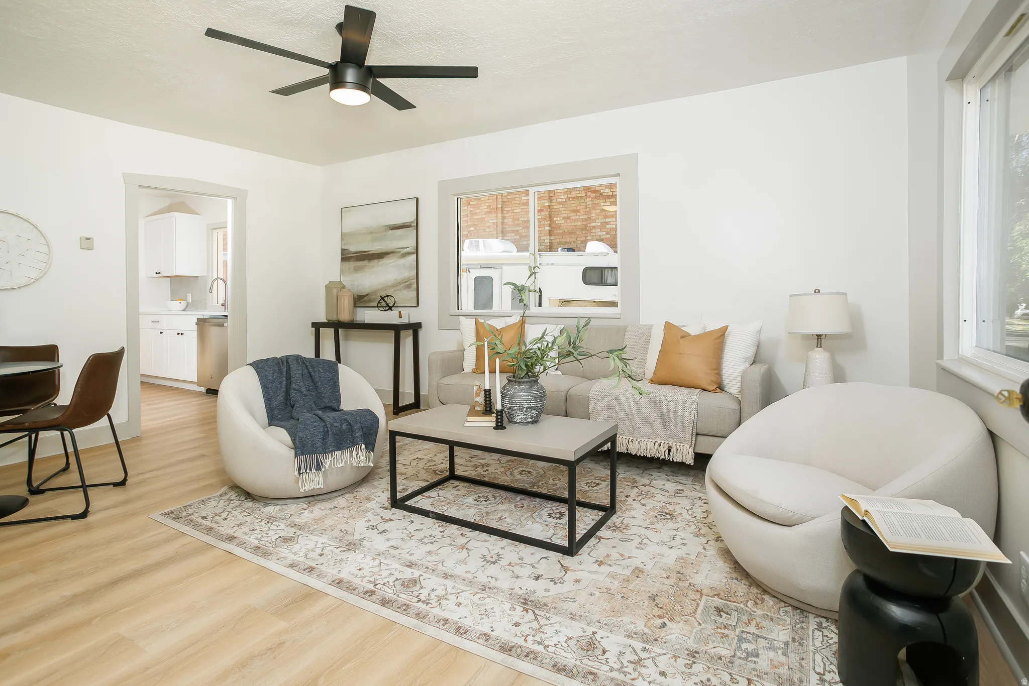 Wood-finish flooring, white walls, and a contemporary ceiling fan with integrated lighting