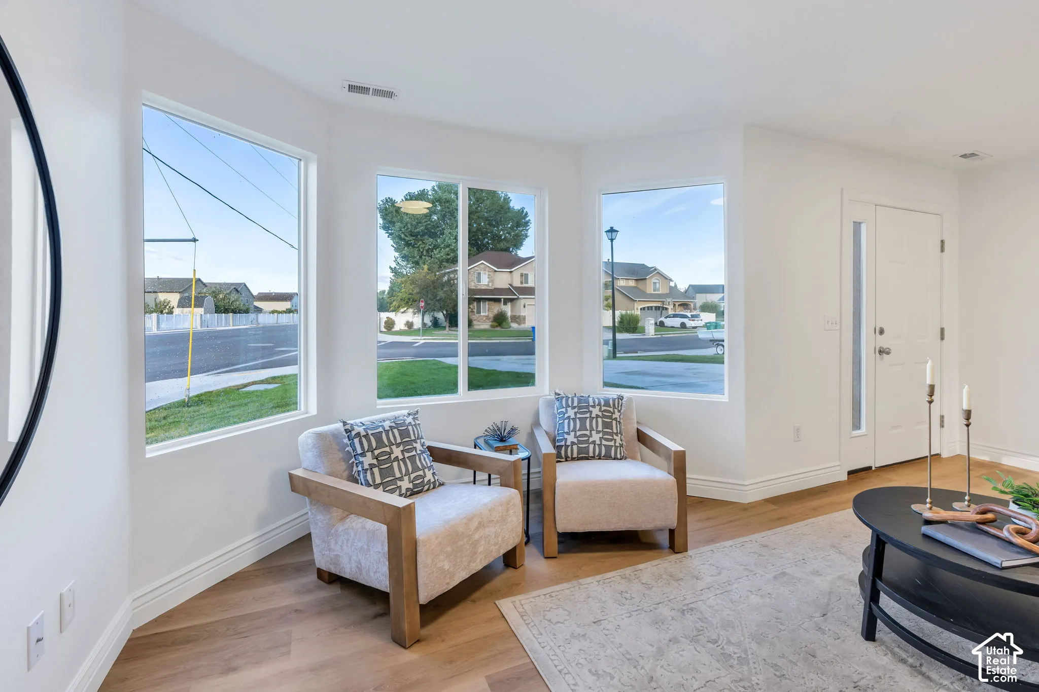 Light wood-finish flooring, white walls, and multiple windows
