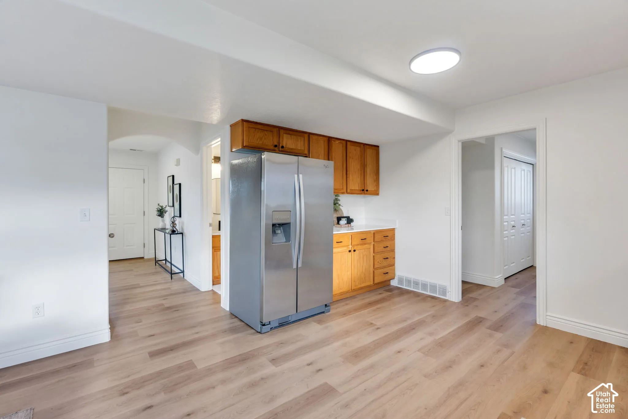 Wood-finish flooring throughout, with a built-in stainless steel refrigerator and wood cabinetry