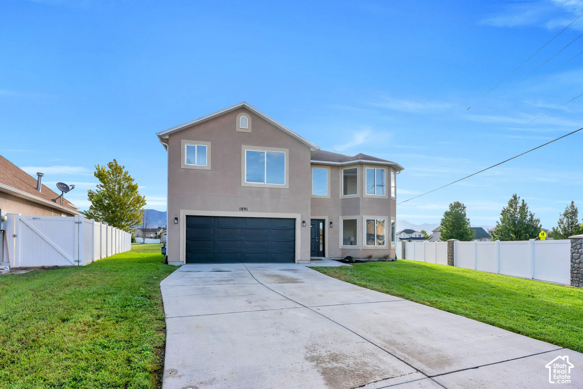 Stucco exterior with an attached garage and a concrete driveway