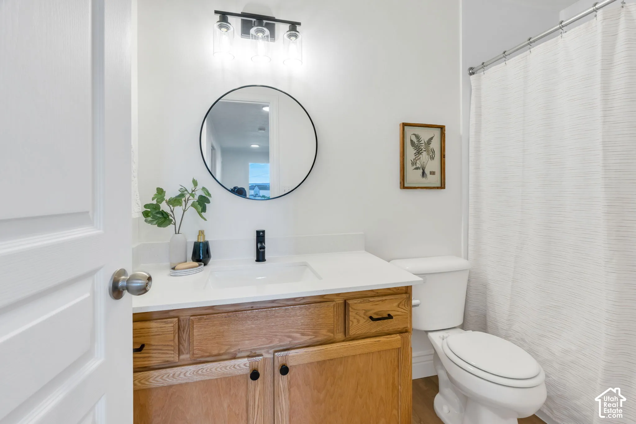 Wood-finish vanity with a white countertop and undermount sink