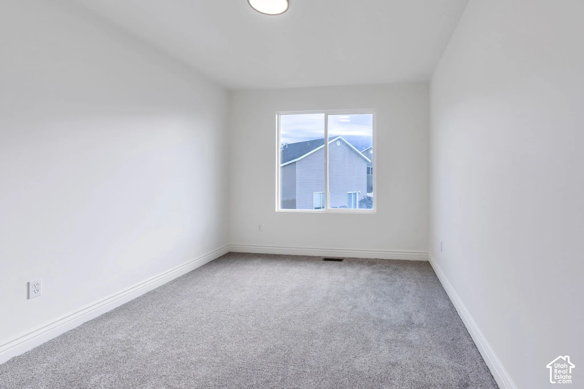 Neutral color palette, window with exterior exposure, recessed ceiling light, wall-to-wall carpeting, and white trim
