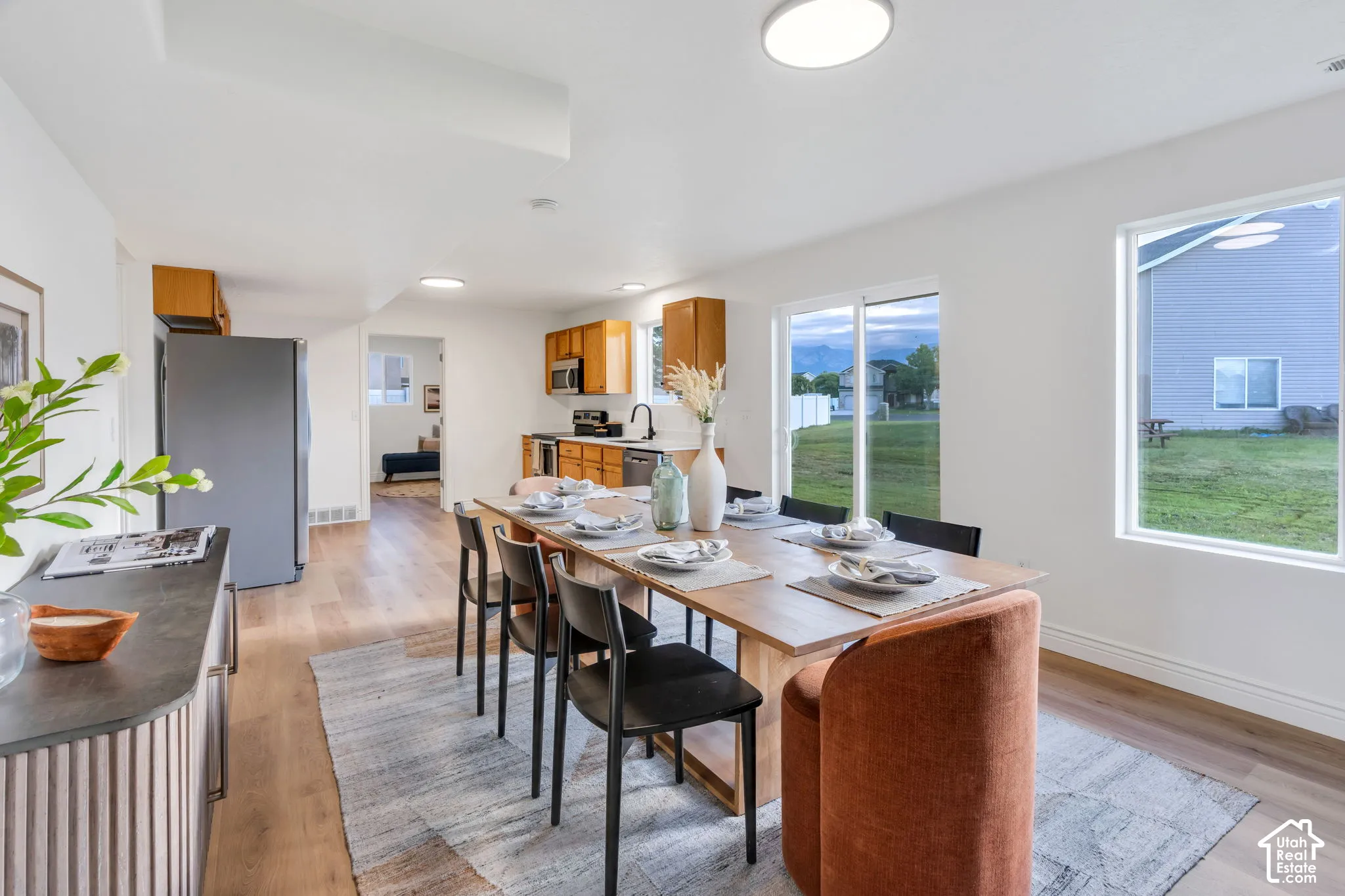 Open-concept living area with wood-finish flooring, recessed lighting, and large windows