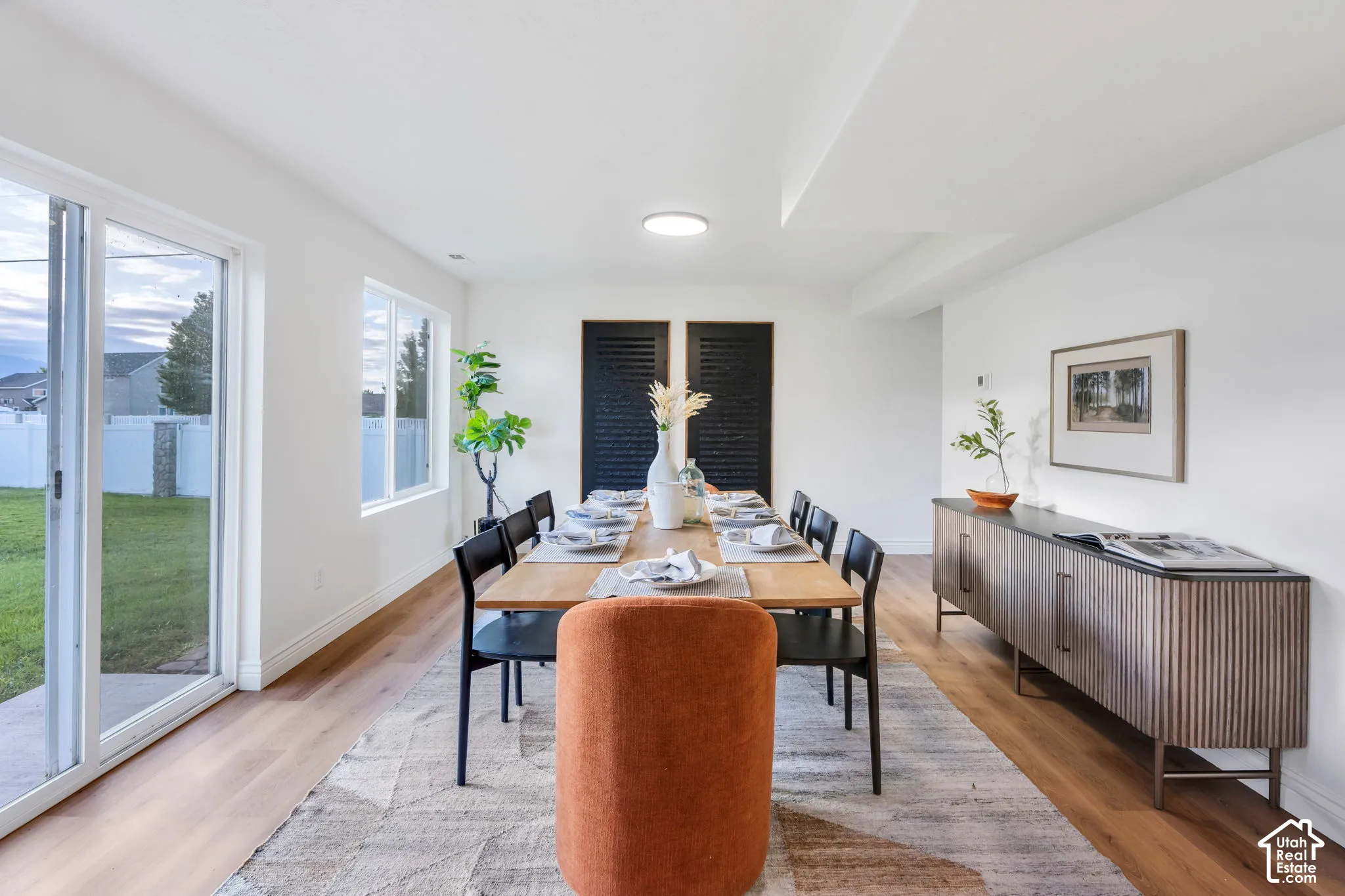 Spacious dining area featuring wood-finish flooring, recessed lighting, and white walls