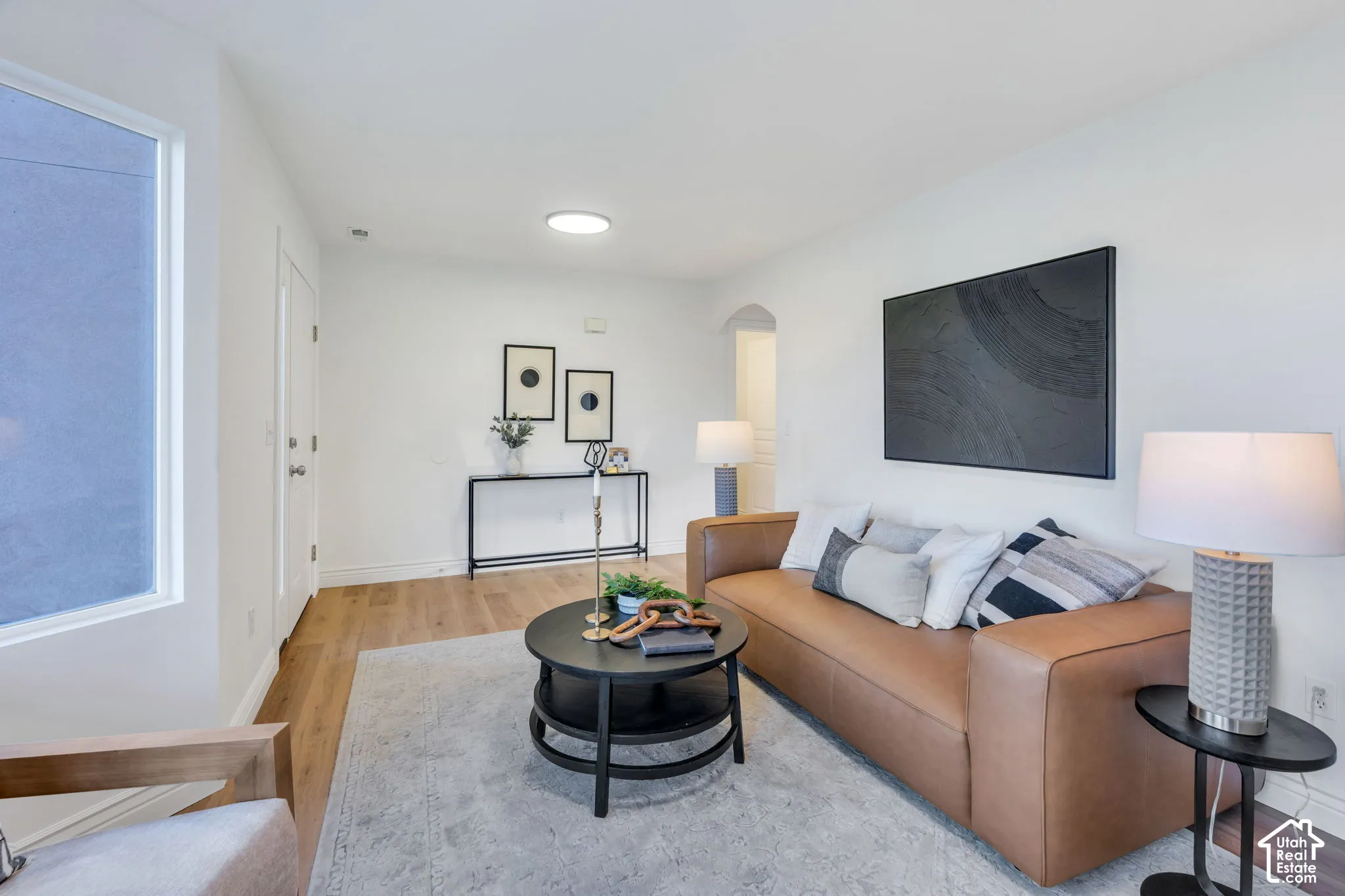 Neutral wall color, wood-finish flooring, recessed lighting, and an arched doorway