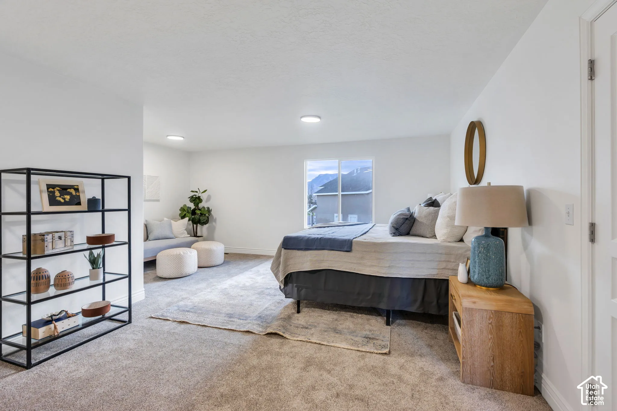 Recessed lighting, large window with mountain scenery, white interior walls, and light-toned carpeting