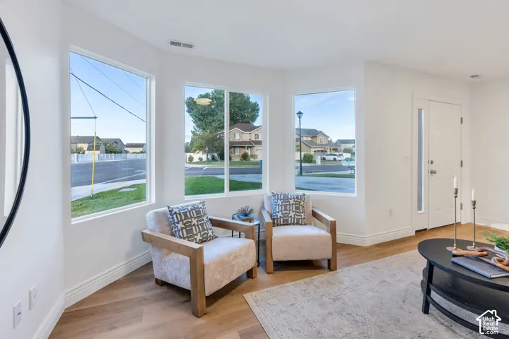 Light wood-finish flooring, white walls, and multiple windows