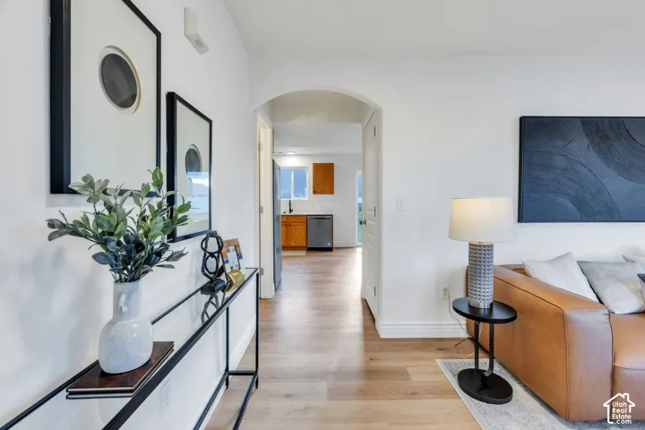 Light wood-finish flooring extending through an arched doorway