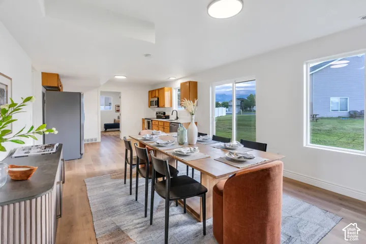 Open-concept living area with wood-finish flooring, recessed lighting, and large windows