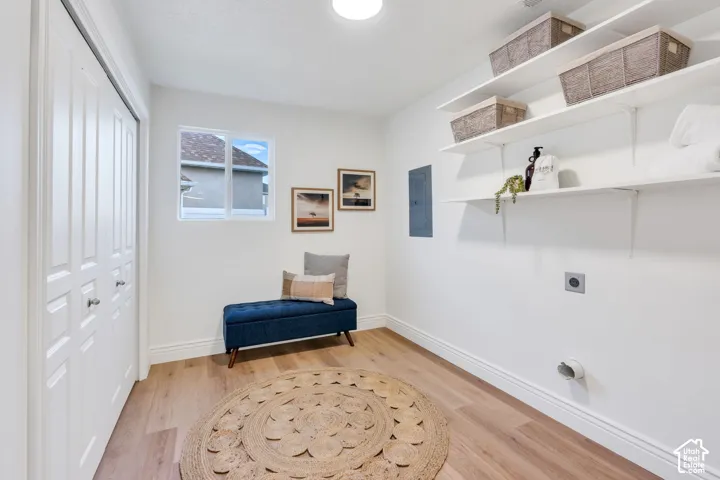 Recessed lighting, wood-finish flooring, built-in shelving, white bi-fold closet doors, and a window with white trim