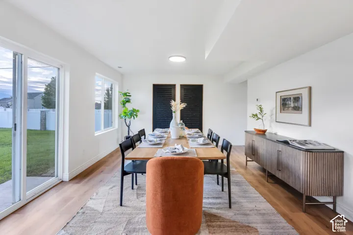 Spacious dining area featuring wood-finish flooring, recessed lighting, and white walls