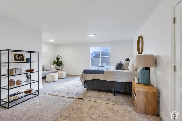 Recessed lighting, large window with mountain scenery, white interior walls, and light-toned carpeting