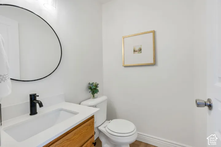 White vanity with integrated sink, black faucet, and round black-framed mirror