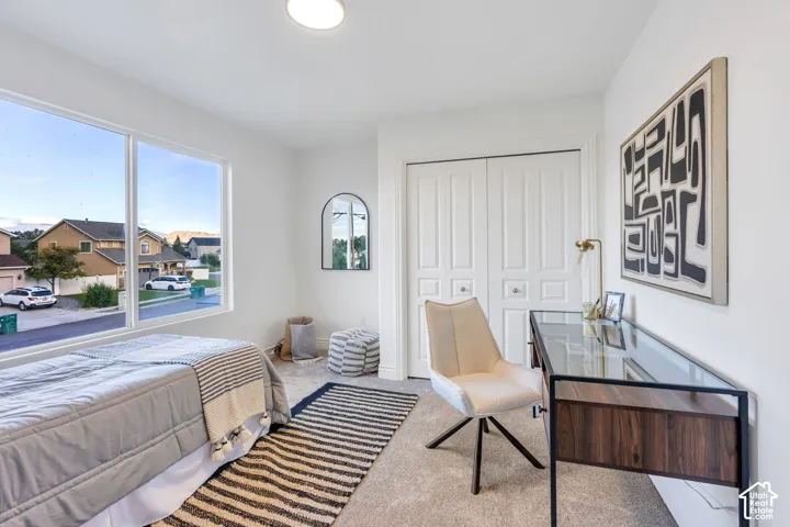 Expansive window providing ample natural light, soft carpet flooring, recessed ceiling light, and bi-fold closet doors
