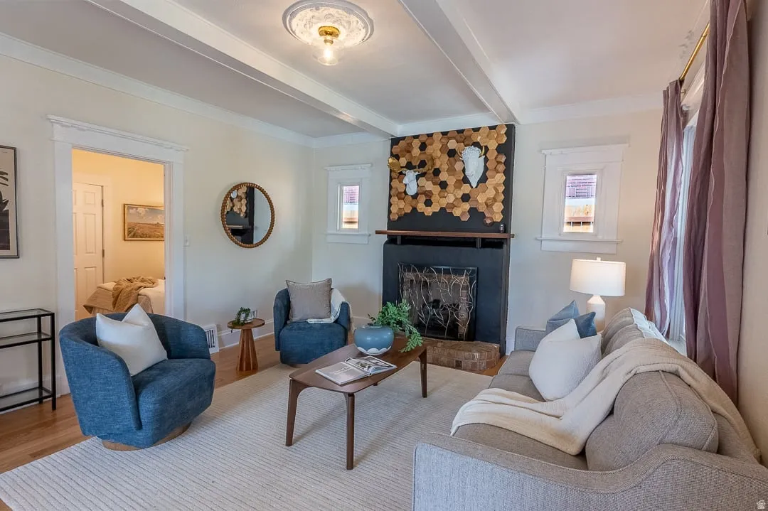 Living area featuring a fireplace with a dark-toned mantel, light-toned walls, wood-finish flooring, and a decorative ceiling medallion