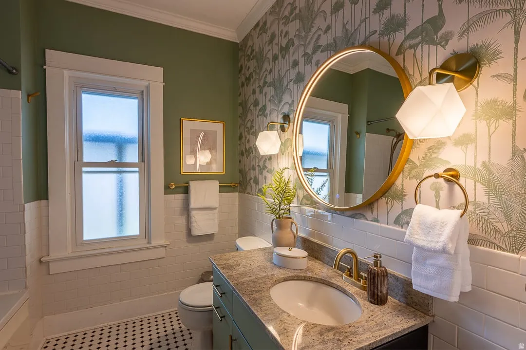Bathroom featuring a single vanity with an undermount sink, granite countertop, and brass-finish faucet