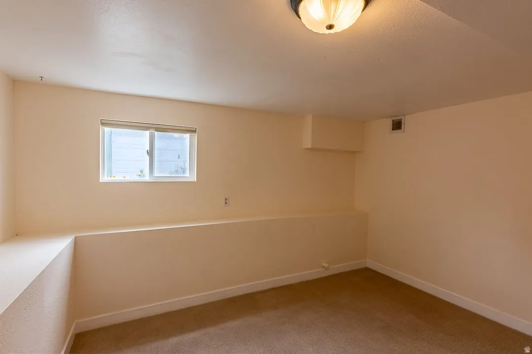 Recessed window with white blinds, neutral wall paint, and ceiling-mounted light fixture