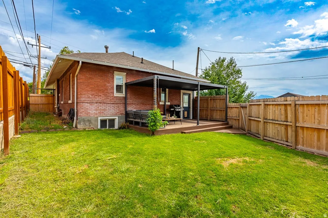 Brick residence with a spacious rear yard featuring mature landscaping and a manicured lawn