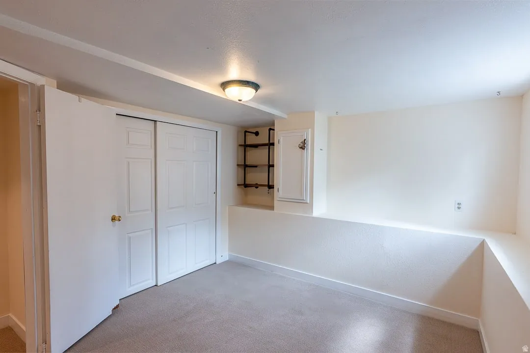 Wall-to-wall carpeting with light-colored walls and a semi-flush mount ceiling fixture
